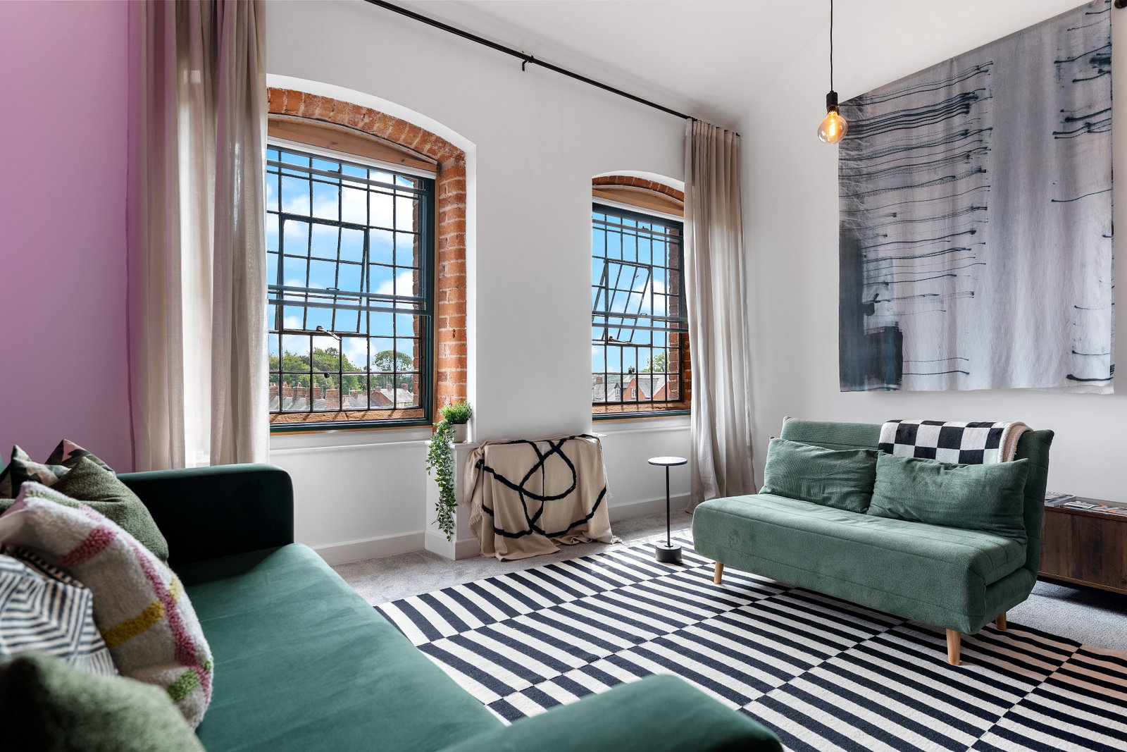Open-plan living area with vaulted ceiling and tall feature windows