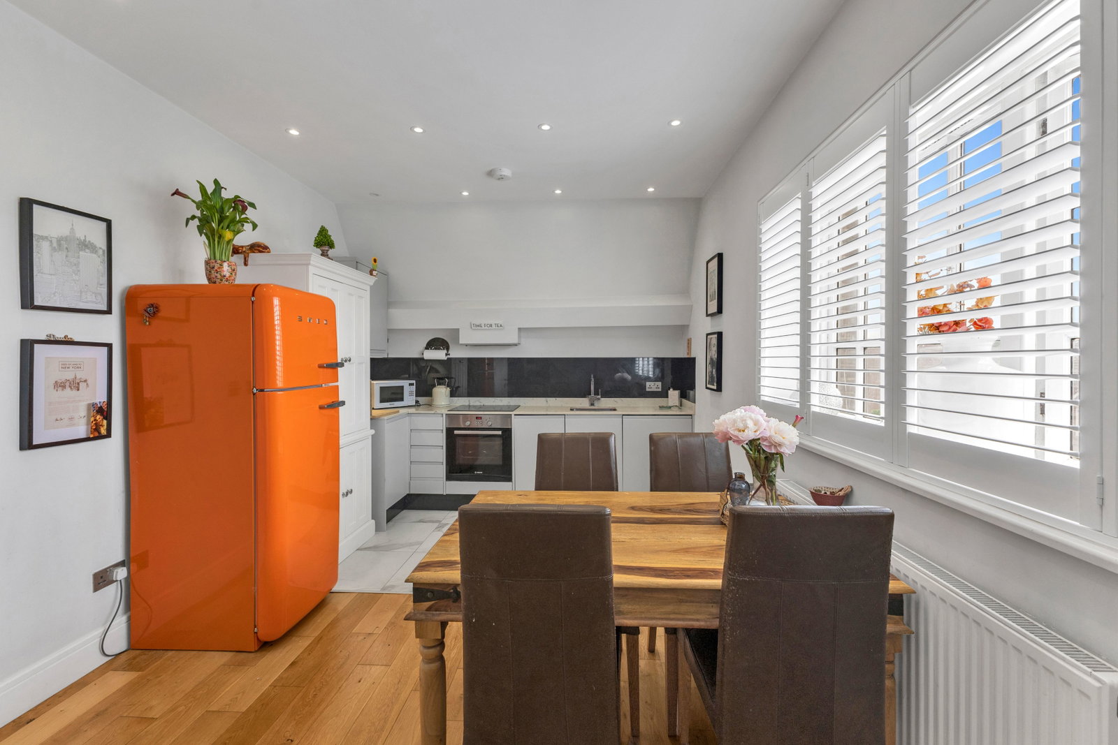 Open-plan kitchen, dining and day room with large shuttered windows