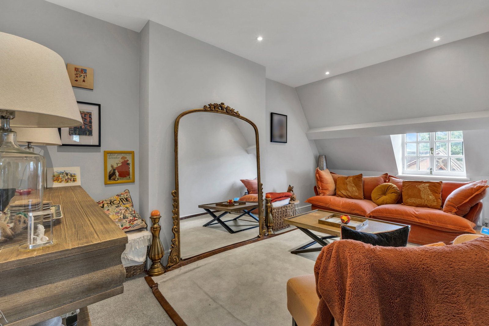 Separate sitting room with high ceilings and a large gilt mirror